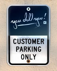 You Doll You Eyelashes parking lot sign